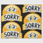 Trauriges Sorry Emoji Gesicht hält Entschuldigungs Geschenkpapier (Flach)
