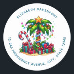 Tropical Christmas Palm Tree Address Runder Aufkleber<br><div class="desc">Adressieren Sie Aufkleber mit einem saisonalen Urlaubsbild. Eine tropische Palme,  die mit festlichen Lichtern dekoriert ist und auf der ein Stern steht. Ein riesiger,  rot-weißer Bonbons,  der aus dem Sand ragt. Weihnachten präsentiert sich unter dem Baum. Whimsical und lustig.</div>