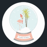 Tropical Island Flamingo Christmas - Pink Runder Aufkleber<br><div class="desc">Ein Winter-/Weihnachtsaufkleber mit einer Illustration eines rosa Flamingo in einer Schneeglobe. Flamingo trägt einen rot gestreiften Schal und Hut,  während er auf einer schneebedeckten Insel mit zwei Palmen steht. Die rosa Basis sagt: "WARM WISHES."</div>