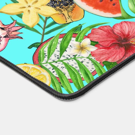 Tropische Mischfrüchte, Blume und Blätter auf blau Schreibtischunterlage (Ecke)