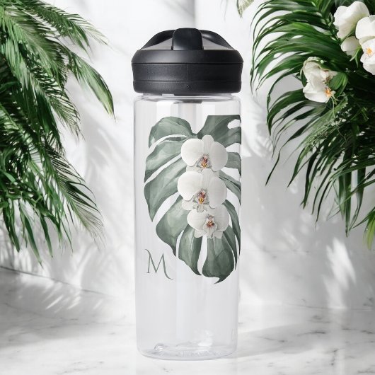 Tropische weiße Orchideen auf Monstera mit Monogra Trinkflasche