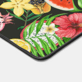 Tropisches Mischobst, Blume und Blätter auf schwar Schreibtischunterlage (Ecke)