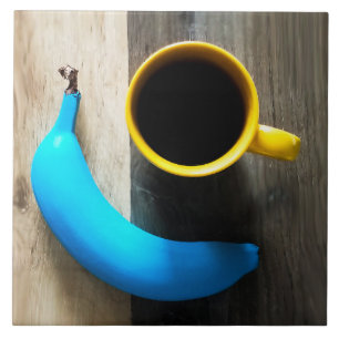 Türkisfarbene Banane und Tasse mit gelbem Kaffee - Fliese