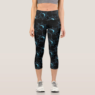 Türkisfarbenes Sonnensymbol auf schwarzem Hintergr Capri Leggings