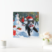 Tuxedo Katze läuft im Schnee mit Weihnachtsmütze Quadratische Wanduhr (Zuhause)
