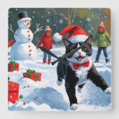 Tuxedo Katze läuft im Schnee mit Weihnachtsmütze Quadratische Wanduhr (Vorderseite)