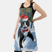 Tuxedo Katze läuft im Schnee mit Weihnachtsmütze Schürze (InSitu)