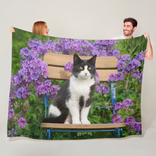 Tuxedo Katze sitzt auf einem Gartenstuhl mit Blume Fleecedecke (Beispiel)