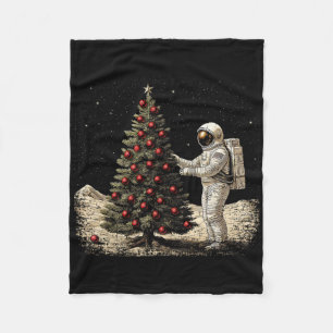 Urlaubsastronaut mit einem Weihnachtsbaum auf dem  Fleecedecke