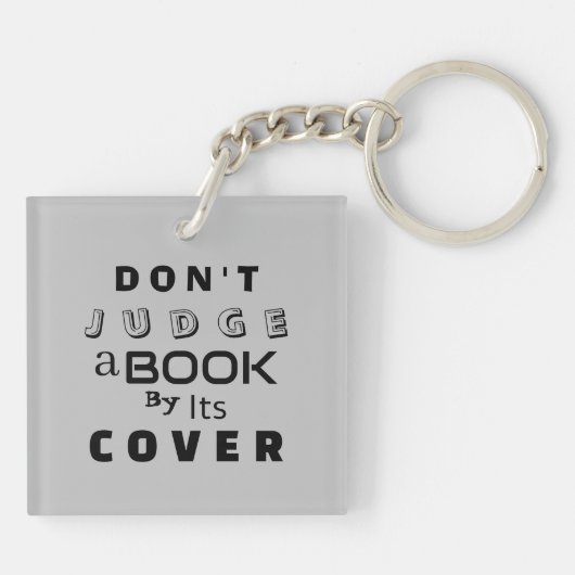 "Urteile ein Buch nicht nach seinem Cover" hellgra Schlüsselanhänger (Rückseite)