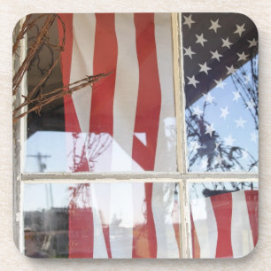 USA, Oregon, Shaniko. Flagge im Fenster nahe bei Untersetzer