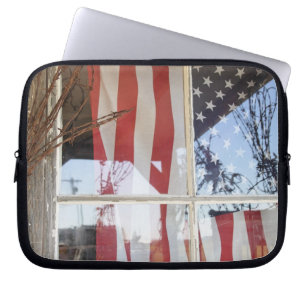 USA, Oregon, Shaniko. Flagge im Fenster neben Laptopschutzhülle