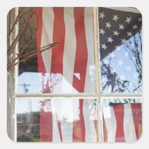 USA, Oregon, Shaniko. Flagge im Fenster neben Quadratischer Aufkleber