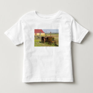 USA, Oregon, Shaniko. Rostiger Vintage-Traktor in Kleinkind T-shirt