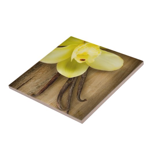 Vanille-Hülsen und Blume über hölzernem Fliese (Seite)