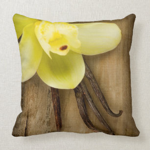 Vanille-Hülsen und Blume über hölzernem Kissen