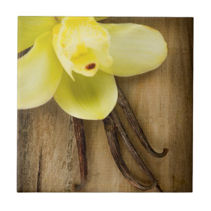 Vanilleschoten und Blüte auf Holzhintergrund Fliese