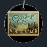 Venice Beach Vintage Reise Keramik Ornament<br><div class="desc">Diese Gruß aus Venedig Beach Vintage Postkartengestaltung verfügt über einen Sandstrand mit einem schönen türkisfarbenen Ozean Wasser und über dem Meer,  einen blauen Himmel mit billigen weißen Wolken. Im Vintage Reisen Stil.</div>