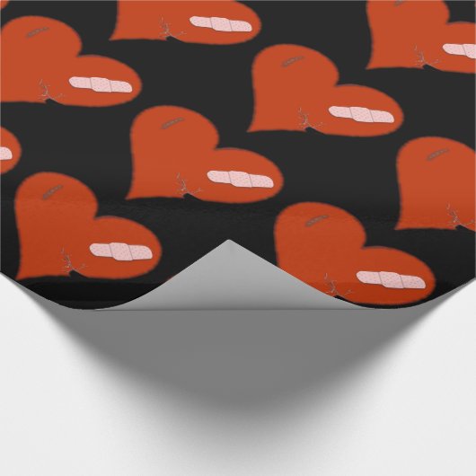 Verletztes Tattered getragenes heraus Herz auf Geschenkpapier (Ecke)