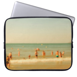 Verschwommenes Strandfoto mit Bokeh. Menschen ents Laptopschutzhülle