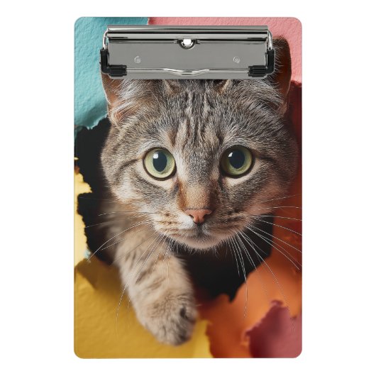 Verspielte getigerte Katze, die durch zerissenes P Mini Klemmbrett (Vorderseite)