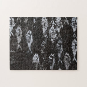 Versteinerte weiße Fische auf schwarzem Puzzle