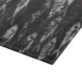 Versteinerte weiße Fische auf schwarzem Schneidebrett (Ecke)