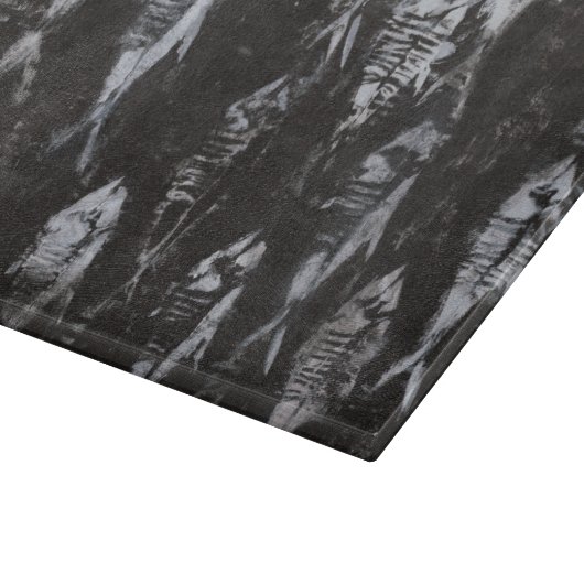 Versteinerte weiße Fische auf schwarzem Schneidebrett (Ecke)