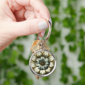 Verzierte Blumenmedaille über hellblauen Hintergru Schlüsselanhänger (Hand)