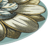 Verzierte Blumenmedaille über hellblauen Hintergru Schneidebrett (Ecke)