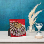 Verzierter Handheld-Lüfter auf einem roten Hinterg Fotoplatte (InSitu)