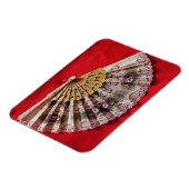 Verzierter Handheld-Lüfter auf einem roten Hinterg Magnet (Linke Seite)