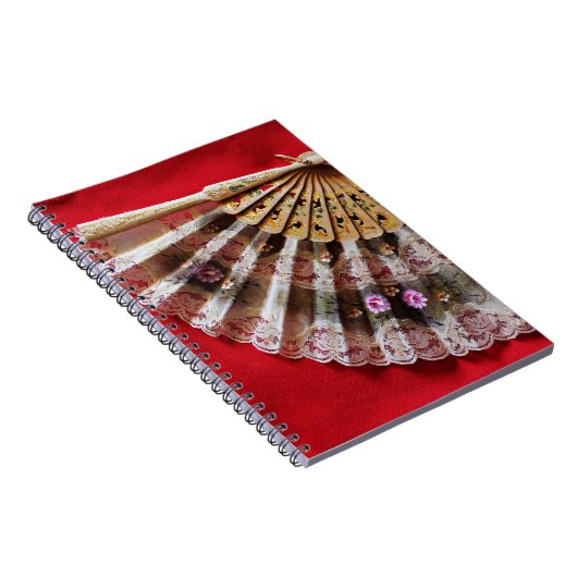 Verzierter Handheld-Lüfter auf einem roten Hinterg Notizblock (Rechte Seite)