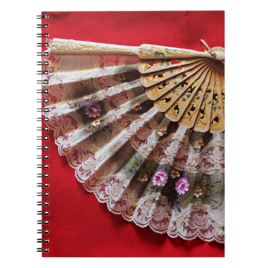 Verzierter Handheld-Lüfter auf einem roten Hinterg Notizblock (Vorderseite)