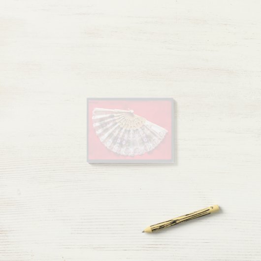 Verzierter Handheld-Lüfter auf einem roten Hinterg Post-it Klebezettel (Auf Schreibtisch)