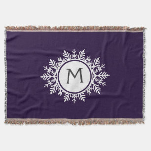 Verziertes weißes Schneeflocke-Monogramm auf Lila Decke