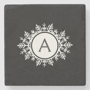 Verziertes weißes Schneeflocke-Monogramm auf Steinuntersetzer