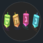 Vier Dreidelsklammern Runder Aufkleber<br><div class="desc">Vier mehrfarbige Dreilinge zeigen Nonne,  Gimel,  Hei und Schien. Nes Gadol Hayah Sham. Ein Chanukah-Design.</div>