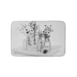 Vier Flaschen und weiße Blume Badematte