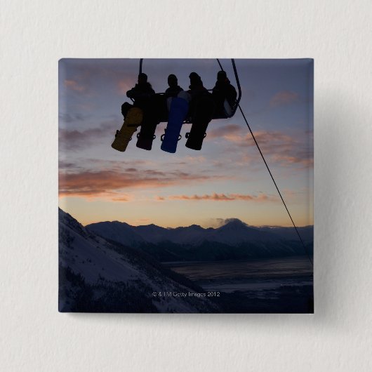 Vier Snowboarder sind auf einem Skilift silhouetti Button (Vorderseite)