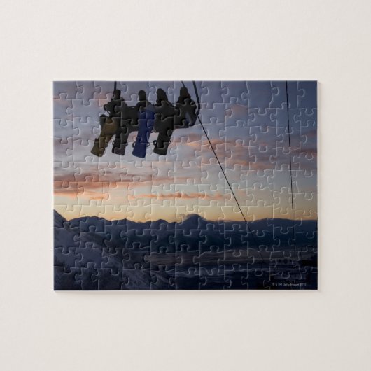 Vier Snowboarder sind auf einem Skilift silhouetti Puzzle (Horizontal)