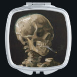 Vincent van Gogh Art Taschenspiegel<br><div class="desc">Vincent van Gogh (Niederländisch, 1853 - 1890) Schädel eines Skeletts mit brennender Zigarette, 1885-86, Öl auf Leinwand Ungerahmt: 32 cm × 24, 5 cm (13 in × 9, 6 in) Früharbeit von Vincent van Gogh. Dieses kleine Gemälde ist Teil der ständigen Sammlung des Van Gogh Museums in Amsterdam. Es wurde...</div>