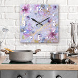 Vintage romantische lila Blütenfarbe Quadratische Wanduhr<br><div class="desc">Fett, weiße, leicht lesbare Ziffern, sowie weiße, lila und blaue Blume in Aquarellfarbe, überlagern weiße Schrift auf einem wunderschönen, sanften, halbblauen, goldfarbenen Hintergrund. Genießen Sie Ihr Lieblingszimmer mit dieser eleganten, atemberaubenden und stilvollen Wanduhr. Wählen Sie eine runde oder quadratische Uhr Gesicht. Macht eine wunderbare, elegante Aussage in Ihrer Zuhause! Sie...</div>