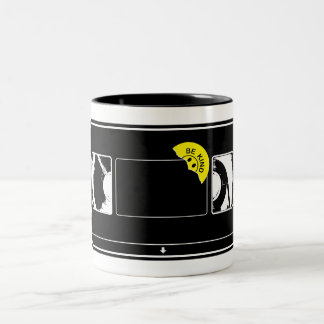 Vintage-Videoband mit 'Be Kind Rewind'-Aufkleber Zweifarbige Tasse