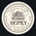 Vintages Skep Local Honey Jar Label Elfenbein Runder Aufkleber<br><div class="desc">Ein hübsches altmodisches Label mit einer zarten doppelten Punktgrenze und einer zarten Linie umgibt dieses helle Honey Jar Label mit Vintager Skep Illustration. Es hat eine doppelte, gekrümmte Textgrenze mit Platz für Apiary Name und Position oben auf dem Etikett, und Honigbeschreibung unten. Das Wort Honey ist das auffälligste Textelement auf...</div>