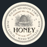 Vintages Skep Local Honey Jar Label Elfenbein Runder Aufkleber<br><div class="desc">Ein hübsches altmodisches Label mit einer zarten doppelten Punktgrenze und einer zarten Linie umgibt dieses helle Honey Jar Label mit Vintager Skep Illustration. Es hat eine doppelte, gekrümmte Textgrenze mit Platz für Apiary Name und Position oben auf dem Etikett, und Honigbeschreibung unten. Das Wort Honey ist das auffälligste Textelement auf...</div>