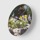 Violas in einem Steintrog. Runde Wanduhr (Winkel)