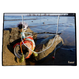 Vissende Fubby op een blikje aan de waterkant. Große Geschenktüte