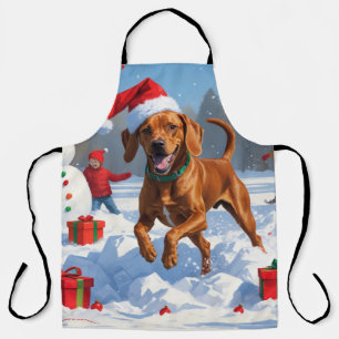 Vizsla läuft im Schnee mit Weihnachtsmütze Schürze