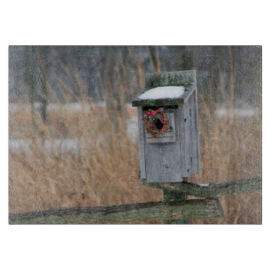 Vogel, Nistkasten mit Weihnachtsgirlande im Winter Schneidebrett